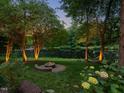 Beautiful backyard with a fire pit and a hammock overlooking a tranquil lake at 105 Highlands Lake Dr, Cary, NC 27518