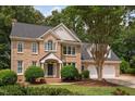 Beautiful brick home with a classic design, lush landscaping, and a welcoming two-car garage at 108 Nimbus Ct, Cary, NC 27513