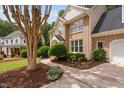 Elegant brick home with meticulous landscaping, a curved walkway, and a tree-lined street at 108 Nimbus Ct, Cary, NC 27513