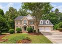 Beautiful two-story brick home featuring a two-car garage, landscaped yard, and mature trees in a lush setting at 108 Nimbus Ct, Cary, NC 27513