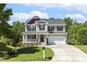 Charming two-story home featuring a welcoming front porch and well-maintained landscaping at 109 Lyngrove St, Holly Springs, NC 27540