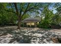 Spacious backyard with a large patio area, mature trees, and a storage shed at 1111 College St, Oxford, NC 27565