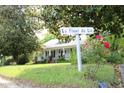 Charming home with a welcoming front yard, blooming roses, and a sign reading 'La Fleur de Lis' at 1111 College St, Oxford, NC 27565