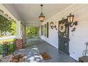 Inviting front porch with decorative lighting, wreath, and views of the landscaped yard at 1111 College St, Oxford, NC 27565