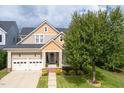 Inviting exterior view of a two-story home featuring a well-manicured lawn, two-car garage, and charming front porch at 121 Bridgegate Dr, Cary, NC 27519