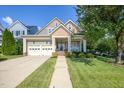 Inviting exterior view of a two-story home featuring a well-manicured lawn, two-car garage, and charming front porch at 121 Bridgegate Dr, Cary, NC 27519