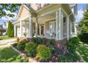 Inviting front porch with white columns, rocking chairs, and well-maintained landscaping at 121 Bridgegate Dr, Cary, NC 27519