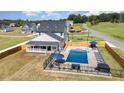 Beautiful aerial view of a home featuring a large in-ground pool, manicured lawn, and fenced backyard at 1302 Reading Ct, Burlington, NC 27217