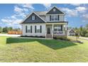 Charming two-story home with a welcoming front porch and well-manicured lawn and stylish landscaping at 1302 Reading Ct, Burlington, NC 27217