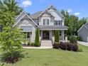 An eye-level shot of this beautiful two-story home boasting a manicured lawn and covered front porch at 1308 Mackinaw Dr, Wake Forest, NC 27587
