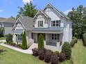 Beautifully landscaped two-story home with manicured lawn and covered porch with stairs to front door at 1308 Mackinaw Dr, Wake Forest, NC 27587