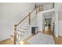 A luxurious two story foyer features a staircase with white banister and wooden handrail, plus paneled walls at 1308 Mackinaw Dr, Wake Forest, NC 27587