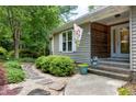 Inviting entrance with stone pathway, lush bushes, and a seasonal decorative flag at 1416 Dunbar Ct, Cary, NC 27511