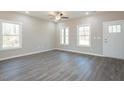Bright living room with large windows, hardwood floors, ceiling fan, and fresh paint at 175 Tupelo Dr, Spring Hope, NC 27882
