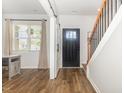 Bright entryway features hardwood floors, staircase with black iron spindles, and access to a sliding barn door at 19 Cecina Ct, Clayton, NC 27527