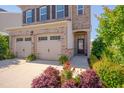 Close-up of a well-kept home exterior with a two-car garage, tidy landscaping, and an inviting front door at 1904 Birdhouse Ln, Wake Forest, NC 27587