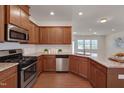 Updated kitchen with stainless steel appliances, granite counters, and wood cabinetry, and hardwood floors at 1904 Birdhouse Ln, Wake Forest, NC 27587