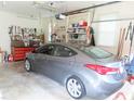 A gray Hyundai Elantra parked inside a spacious two-car garage with storage and tools at 2000 Howson Rd, Raleigh, NC 27603