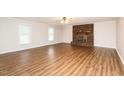 Spacious living room featuring new hardwood floors and a beautiful brick fireplace at 201 E Laramie Dr, Mebane, NC 27302