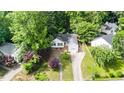 Aerial view of a well-maintained home with a landscaped yard and a driveway leading to the garage at 203 Needle Park Dr, Cary, NC 27513