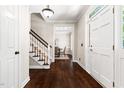Classic foyer with hardwood floors, staircase with white banister, and view into the dining room at 206 Kettlebridge Dr, Cary, NC 27511