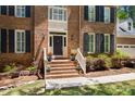 Inviting front entrance with brick steps, white railings, and potted plants for a welcoming feel at 206 Kettlebridge Dr, Cary, NC 27511
