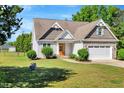 Traditional home with a manicured lawn, complemented by mature trees and a partially fenced yard at 2062 Montgomery Dr, Franklinton, NC 27525