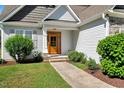 Inviting front entrance with a charming wooden door, surrounded by lush landscaping and a well-kept lawn at 2062 Montgomery Dr, Franklinton, NC 27525