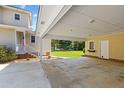 View of the home's attached car port with concrete flooring and an outdoor area at 207 N Hopkins Ave, Spring Hope, NC 27882