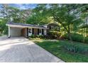 Brick home featuring a carport and a well-manicured lawn with lovely landscaping at 241 E Cornwall Rd, Cary, NC 27511