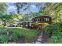 Charming brick home with lush landscaping, healthy green lawn, and decorative walkway at 241 E Cornwall Rd, Cary, NC 27511