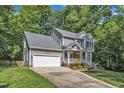 Charming two-story home with a two-car garage, bright yellow front door and a welcoming front lawn area at 2513 Myrtle Ln, Hillsborough, NC 27278