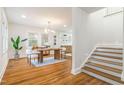 Dining area with a wooden table, stylish chairs, and open flow to the staircase and updated kitchen at 2515 W Club Blvd, Durham, NC 27705