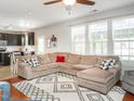 Cozy living room with plush sectional sofa, decorative rug, and bright natural light from large windows at 2605 Mcdougall Dr, Burlington, NC 27217