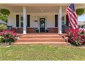Charming front porch featuring brick steps, white columns, and flowering plants, enhancing the home's curb appeal at 404 W E St, Erwin, NC 28339