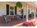 Inviting front porch showcasing tiled flooring, comfortable seating, and vibrant floral arrangements for a cozy ambiance at 404 W E St, Erwin, NC 28339