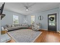Cozy living room with light blue walls, hardwood floors, neutral furniture, and natural light from multiple windows at 404 W E St, Erwin, NC 28339