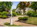 Exterior view of the home's address post, front yard and driveway lined with manicured shrubbery at 4404 Yadkin Dr, Raleigh, NC 27609