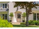 Beautiful painted brick facade with manicured landscaping and trees flanking the home's front door at 4404 Yadkin Dr, Raleigh, NC 27609