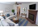 Bright living room with a fireplace, ceiling fan and stylish decor at 4908 Mandel Rd, Durham, NC 27712