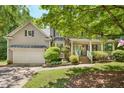 Charming two-story home with a covered front porch, manicured landscaping, and an attached two-car garage at 6 Gasper Ct, Durham, NC 27713