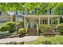 Inviting front porch with brick steps, well-maintained landscaping, and a decorative wreath on the teal front door at 6 Gasper Ct, Durham, NC 27713