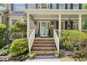 Inviting front porch with brick steps, decorative wreath on the door, and well-maintained landscaping at 6 Gasper Ct, Durham, NC 27713