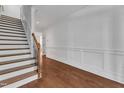 Bright entryway features hardwood floors, white wainscoting, and an open staircase at 644 Angelica Cir, Cary, NC 27518