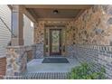 Inviting front porch with stone accents, decorative wreath, and a glass paneled front door at 644 Angelica Cir, Cary, NC 27518
