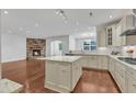 Bright, open kitchen boasts a granite island, hardwood floors, and a stone fireplace for a cozy cooking experience at 644 Angelica Cir, Cary, NC 27518