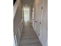 Bright hallway featuring wood-look floors, white trim, and paneled doors at 67 Commons Cir, Clayton, NC 27520