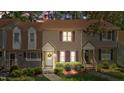 Charming townhouse with tan siding, manicured landscaping, and inviting front entryways at dusk at 704 Benchmark Dr, Raleigh, NC 27615