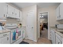 Bright kitchen with white cabinets and modern appliances, next to living area at 704 Benchmark Dr, Raleigh, NC 27615