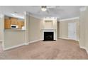 Neutral living room with a fireplace and open access to kitchen area at 711 Providence Glen Dr, Chapel Hill, NC 27514